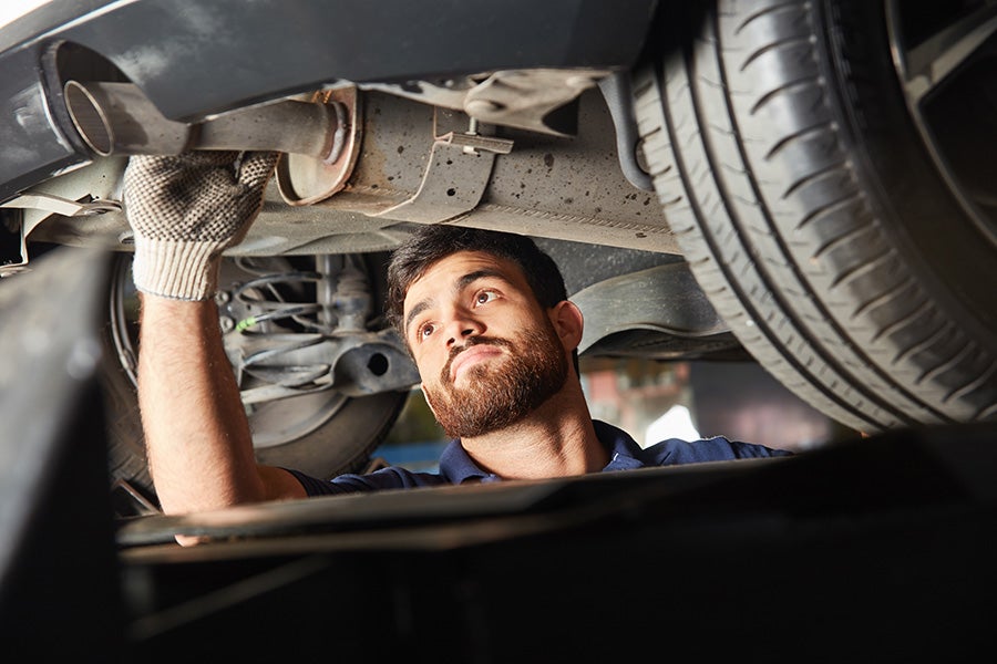 Technician working on a car exhaust