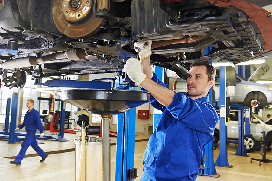 Car Technician Working under an elevated Car